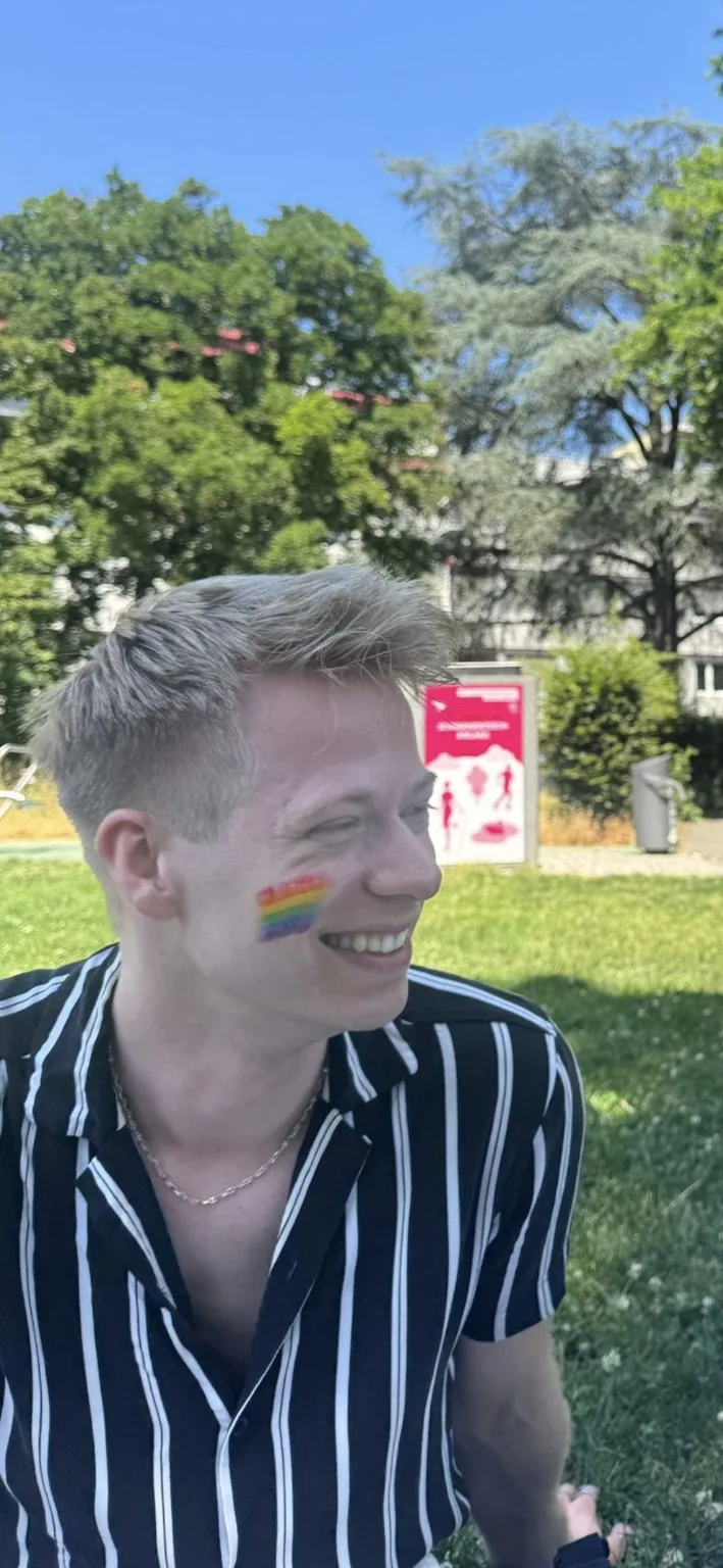 Christian von Rappard lacht, mit einer kleinen Regenbogenflagge auf der Wange